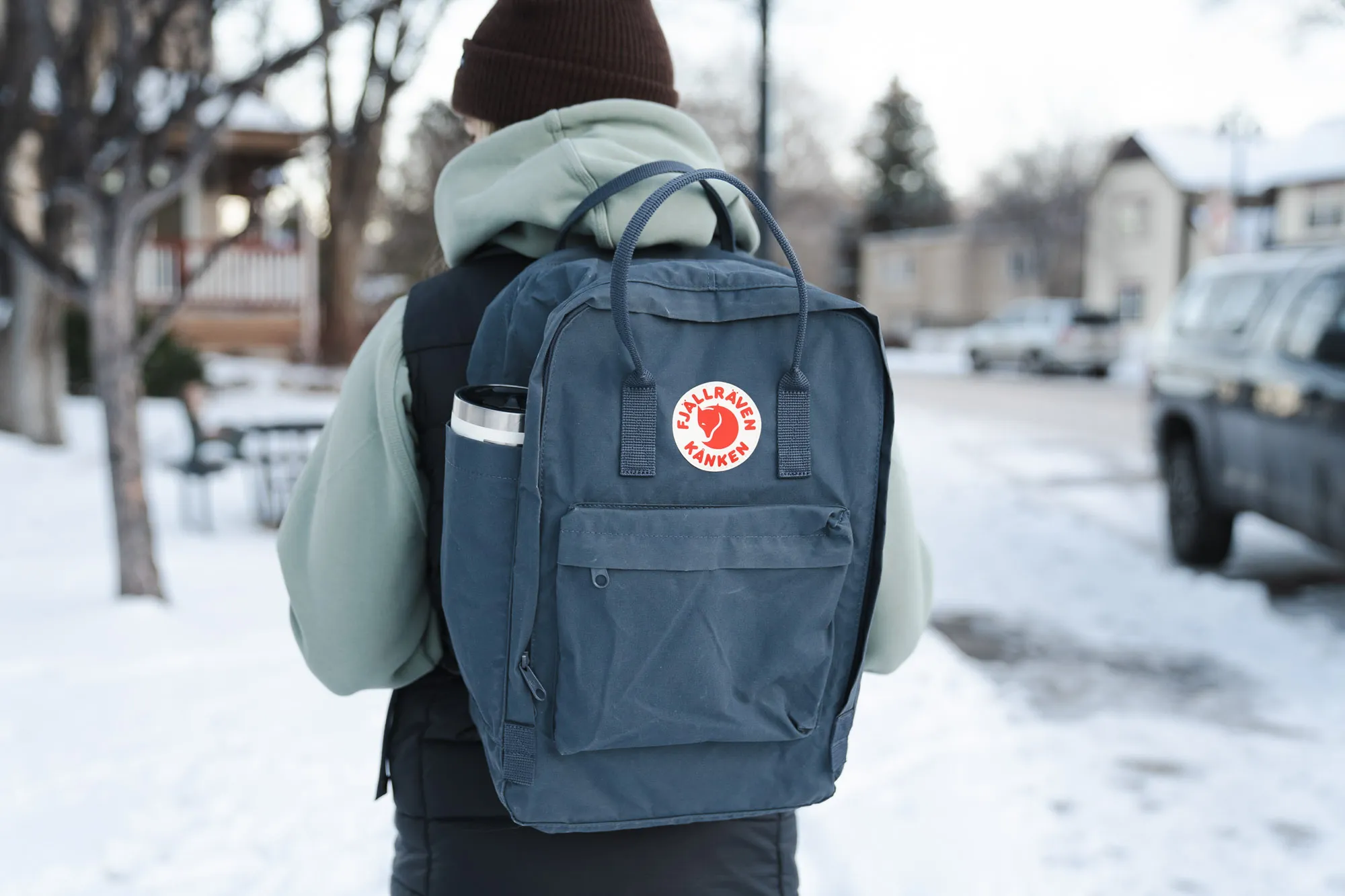 一位女士背着 Fjallraven Kanken 背包走在科罗拉多州一条白雪皑皑的街道上。 一位女士背着 Fjallraven Kanken 背包走在科罗拉多州一条白雪皑皑的街道上。