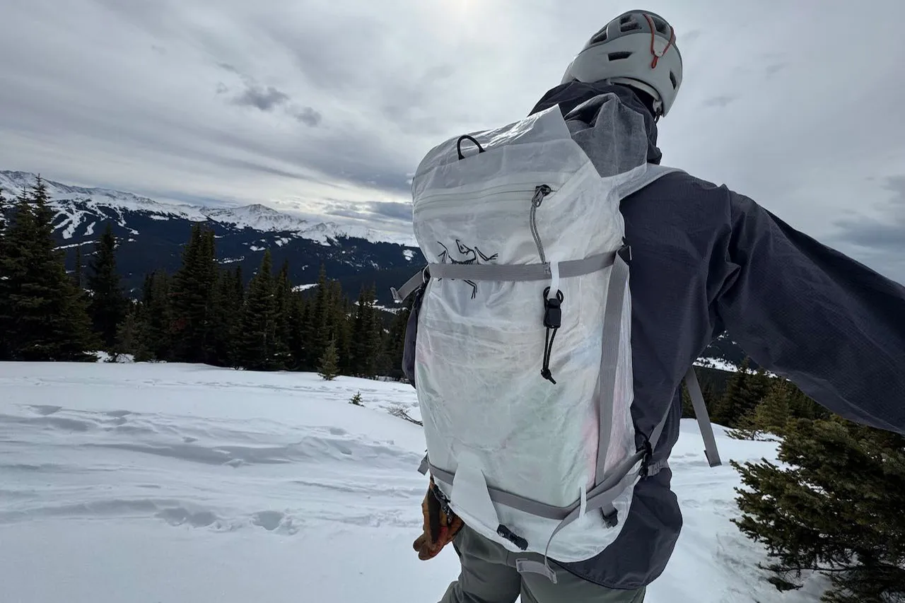 在山谷上方旅行时背着的 Arc'teryx Alpha SL 背包 在山谷上方旅行时背着的 Arc'teryx Alpha SL 背包