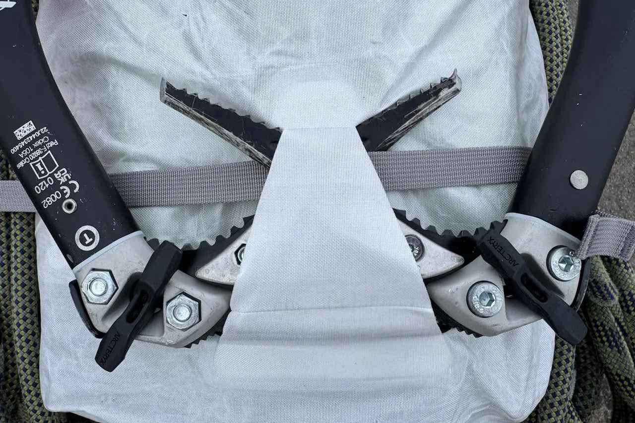 冰镐通过集成式携带系统连接到 Arc'teryx Alpha SL 背包上。 冰镐通过集成式携带系统连接到 Arc'teryx Alpha SL 背包上。