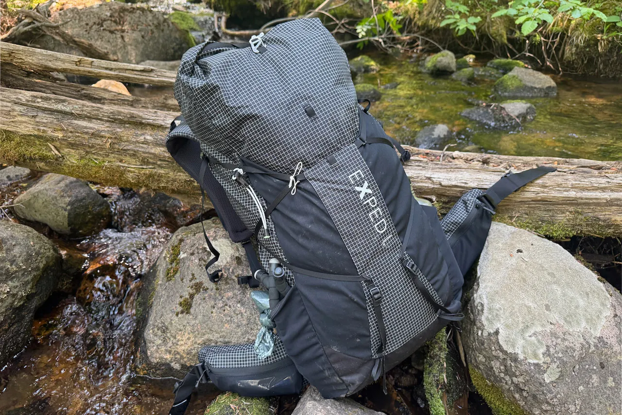 Exped Lightning 50 背包静静地躺在森林溪流旁的岩石上 Exped Lightning 50 背包静静地躺在森林溪流旁的岩石上