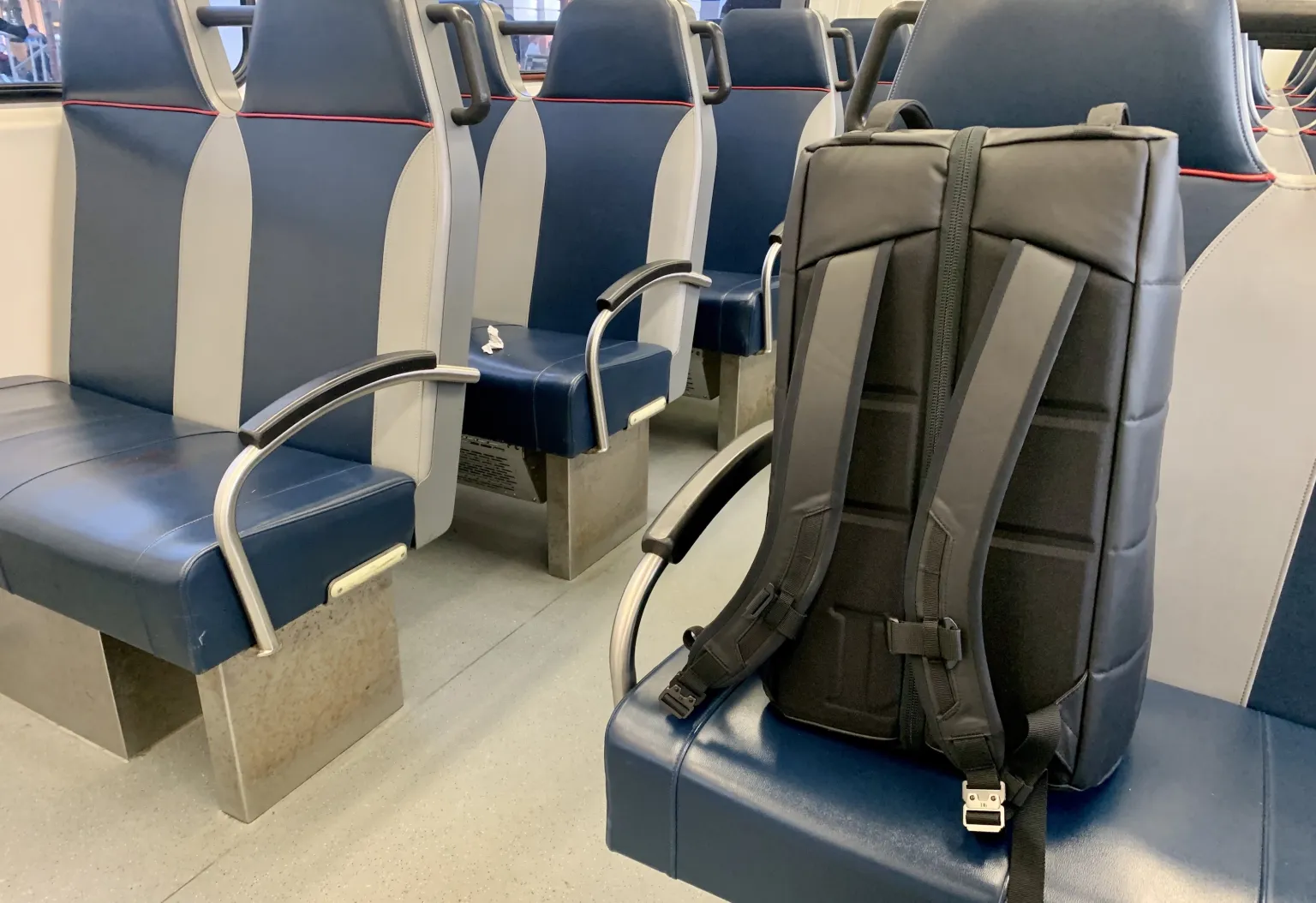 火车座位上的一排座位上放着一个 db 50L 旅行背包。 火车座位上的一排座位上放着一个 db 50L 旅行背包。