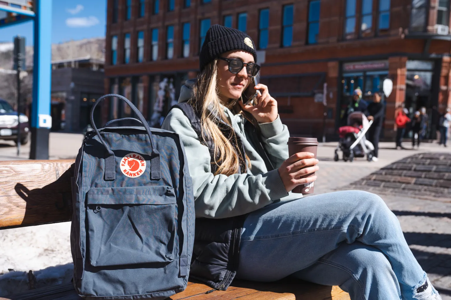 坐在 Fjallraven Kaken 笔记本电脑包旁边的女士 坐在 Fjallraven Kaken 笔记本电脑包旁边的女士