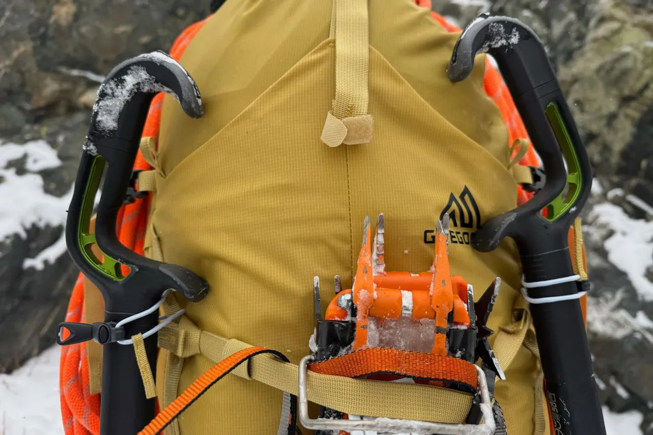 近距离观察固定在 Gregory Alpinisto 30 背包上的冰镐和冰爪。